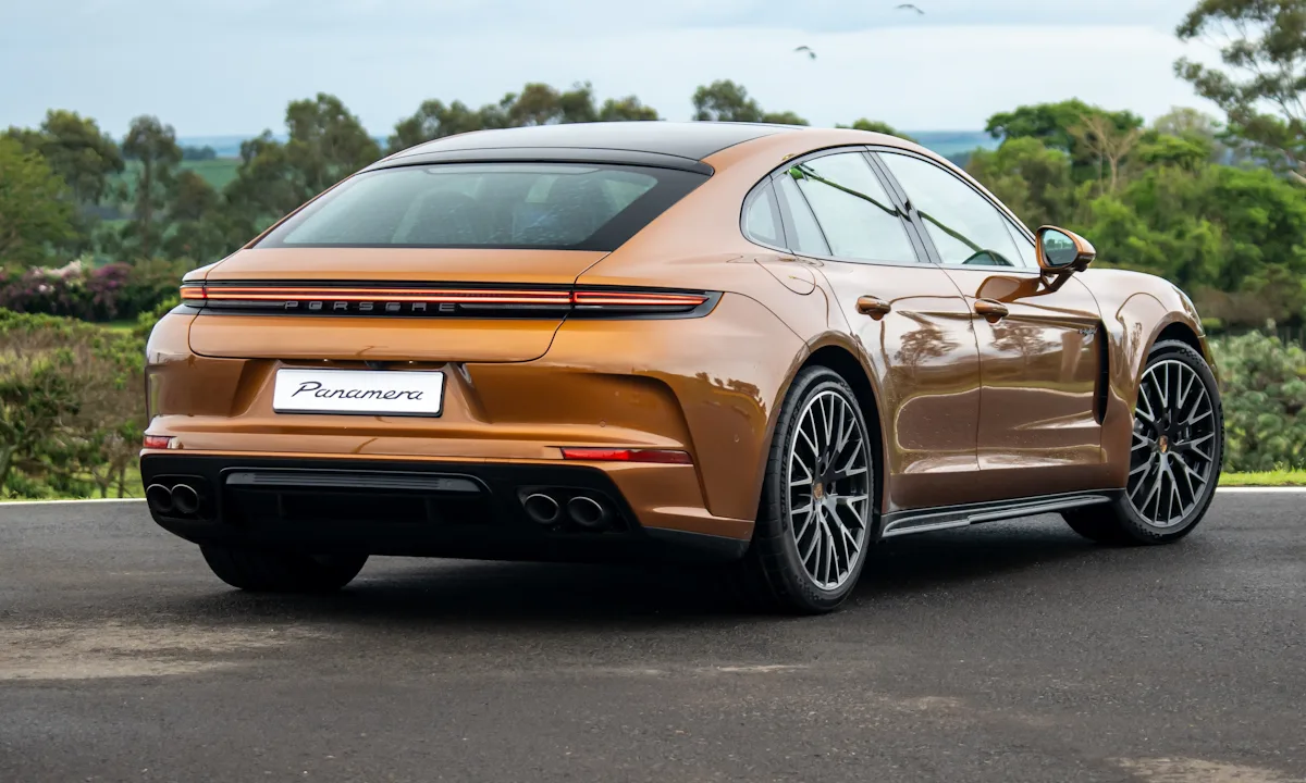 Porsche Panamera 2025 dourado de traseira parado em uma pista molhada