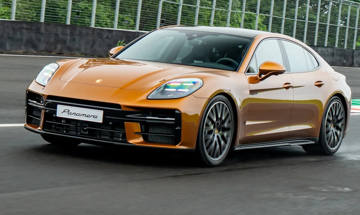 Porsche Panamera 2025 dourado de frente correndo em uma pista molhada